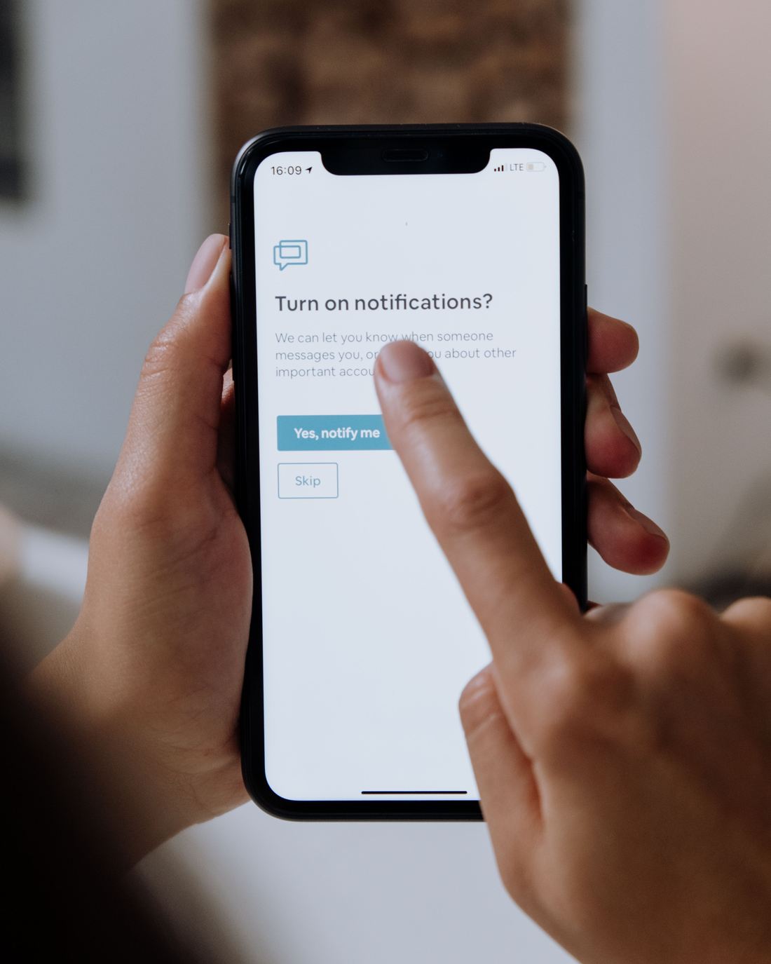 A hand tapping a phone to turn job notifications on