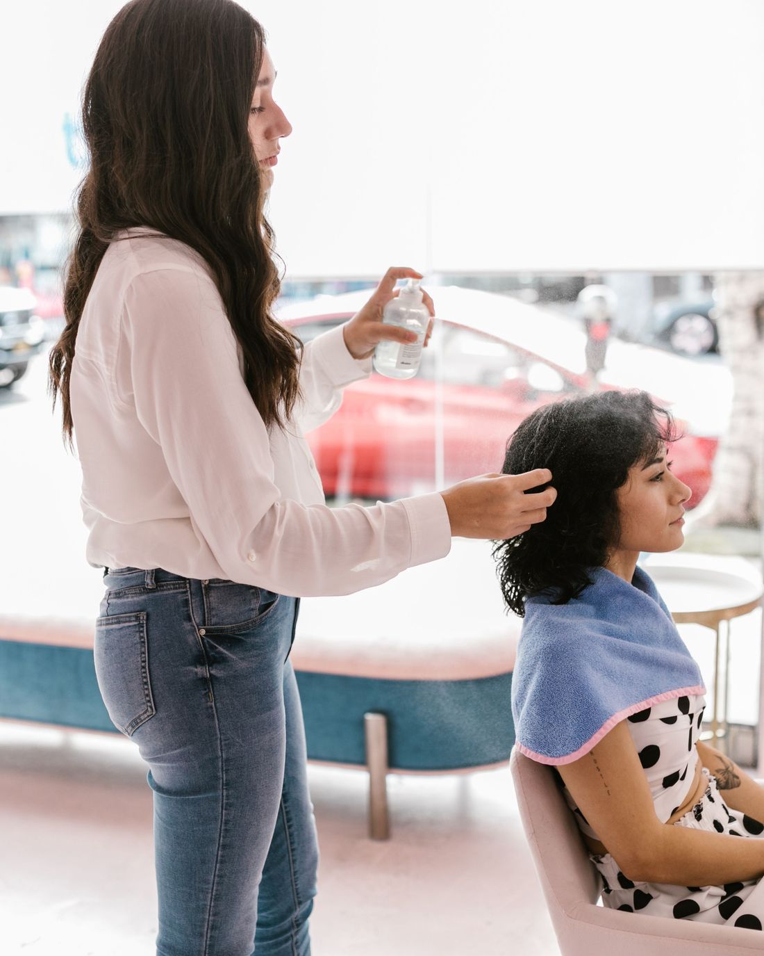 A hairdresser styling a client's hair in a bright salon
