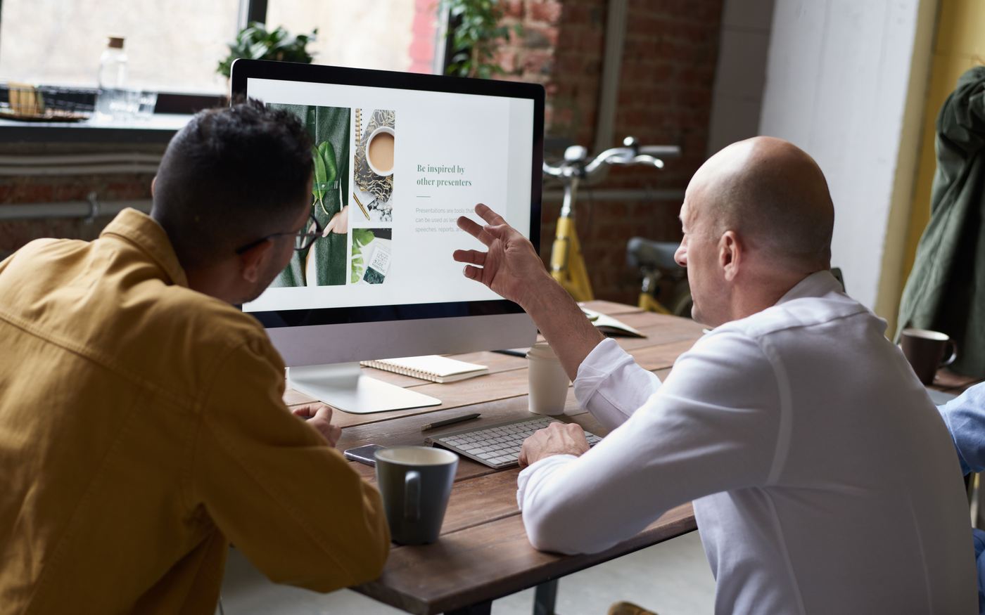 Two colleagues reviewing a website build together on a large screen