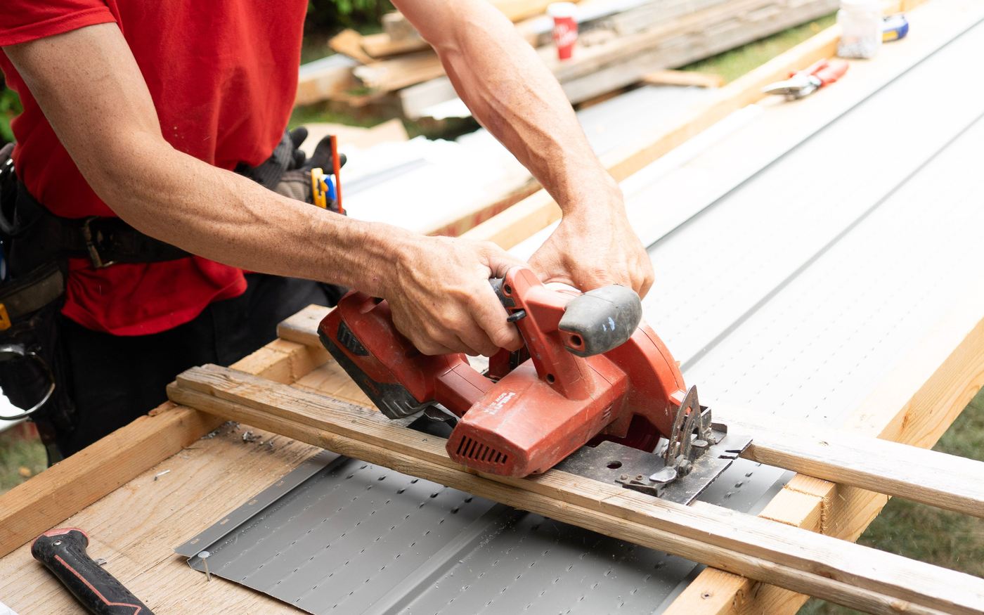 A tradesperson cutting sheet metal on site